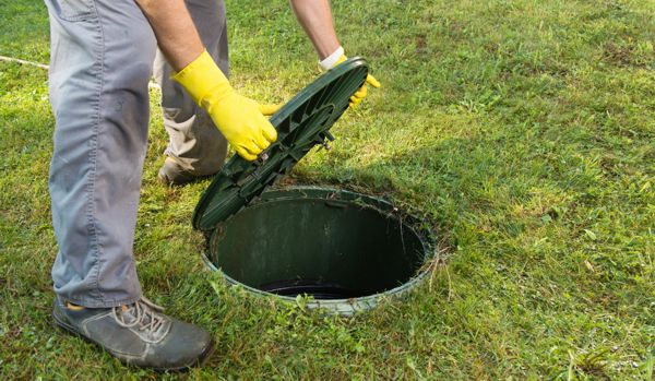 image of person lifting the lid off a Septic tank
